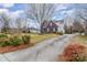 Brick home with blue shutters, landscaping, and long driveway at 7705 Windsor Forest Pl, Harrisburg, NC 28075