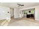 Open-concept living room leading to kitchen, featuring neutral carpet and ceiling fan at 828 Renee Ave, Fort Mill, SC 29715