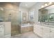 Elegant bathroom with a glass-enclosed shower, soaking tub, and double sink vanity with granite countertop at 1103 N Sharon Amity Rd, Charlotte, NC 28211