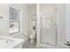 Modern bathroom showcasing a glass-enclosed shower and toilet with a window providing natural light at 1103 N Sharon Amity Rd, Charlotte, NC 28211