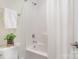 Bright bathroom featuring a tub with white tile surround and shower with white curtain at 1103 N Sharon Amity Rd, Charlotte, NC 28211
