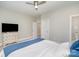 Bright bedroom with a ceiling fan, light walls, and a decorative dresser with a TV on top at 1103 N Sharon Amity Rd, Charlotte, NC 28211