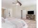 Spacious bedroom with a ceiling fan and a TV console in addition to doorways leading to other rooms at 1103 N Sharon Amity Rd, Charlotte, NC 28211