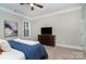 Cozy bedroom with a ceiling fan, window, television, dresser and carpet flooring at 1103 N Sharon Amity Rd, Charlotte, NC 28211