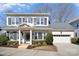 Charming two-story home with light gray brick, dark shutters, and a well-manicured front yard at 1103 N Sharon Amity Rd, Charlotte, NC 28211