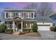 Charming two-story home with a gray brick facade, black shutters, and a well-maintained lawn at 1103 N Sharon Amity Rd, Charlotte, NC 28211