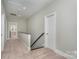 Hallway with carpet flooring and access to additional rooms and staircase at 1103 N Sharon Amity Rd, Charlotte, NC 28211