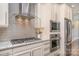 Close up of modern kitchen with stainless steel appliances, granite countertops, and stylish range hood at 1103 N Sharon Amity Rd, Charlotte, NC 28211