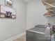 Modern laundry room featuring stainless steel washer and dryer and a stylish wall art piece at 1103 N Sharon Amity Rd, Charlotte, NC 28211