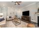 Cozy living room features hardwood floors, a ceiling fan, and a stylish sofa with decorative pillows at 1103 N Sharon Amity Rd, Charlotte, NC 28211