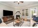 Cozy living room with fireplace, hardwood floors, neutral decor, and plenty of natural light at 1103 N Sharon Amity Rd, Charlotte, NC 28211