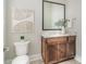 Stylish powder room with a toilet, vanity, and a framed mirror at 1103 N Sharon Amity Rd, Charlotte, NC 28211