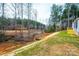 View of the backyard, showing a sloped lot with trees and a small stream at 118 River Ridge Ln, Hickory, NC 28601
