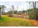 View of the backyard, showing a partially cleared lot with trees and a slope at 118 River Ridge Ln, Hickory, NC 28601