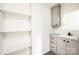 Bathroom with gray vanity, white sink, and floating shelves at 118 River Ridge Ln, Hickory, NC 28601