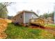Gray manufactured home with a wooden deck and steps in a natural setting at 118 River Ridge Ln, Hickory, NC 28601