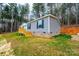 Gray manufactured home with wooden deck and steps, nestled in a wooded setting at 118 River Ridge Ln, Hickory, NC 28601