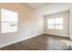 Bedroom featuring wood-look floors, high ceilings, and two bright windows at 135 Jacobs Hill Pl, Troutman, NC 28166