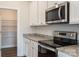 Close-up view of modern kitchen featuring stainless steel appliances and granite countertops at 135 Jacobs Hill Pl, Troutman, NC 28166