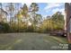 Large backyard with deck, grassy area, and wooded backdrop at 14226 Carlton Woods Ln, Charlotte, NC 28278
