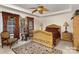 Elegant Primary bedroom with ornate bed and rich colored curtains at 14226 Carlton Woods Ln, Charlotte, NC 28278