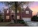 Brick two-story house with a three-car garage and landscaping at 14226 Carlton Woods Ln, Charlotte, NC 28278