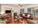 Living room with hardwood floors, fireplace, and leather sofas at 14226 Carlton Woods Ln, Charlotte, NC 28278