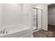 A bathroom featuring a tub, and glass enclosed shower with wood look flooring at 1758 Falls Cove Rd, Newton, NC 28658