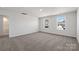 A bedroom with white walls, light carpet, an opening into the walk-in closet, and two large windows at 1758 Falls Cove Rd, Newton, NC 28658