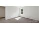 A bright bedroom with neutral carpet, white walls and a window looking out onto the neighborhood at 1758 Falls Cove Rd, Newton, NC 28658