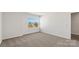 A bedroom with neutral carpet and light walls, with a window showing the exterior of the home at 1758 Falls Cove Rd, Newton, NC 28658