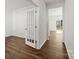 Bright hallway with hardwood floors, white walls, and a glass-paneled door leading to another room at 1758 Falls Cove Rd, Newton, NC 28658