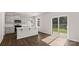 Open kitchen area with white cabinets, stainless steel appliances, and sliding glass doors to the backyard at 1758 Falls Cove Rd, Newton, NC 28658