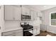 A kitchen with white cabinets, stainless steel appliances, white subway tile backsplash, and dark hardwood floors at 1758 Falls Cove Rd, Newton, NC 28658