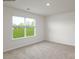 Bright, carpeted bedroom with a large window offering a view of the outdoors at 1766 Falls Cove Rd, Newton, NC 28658