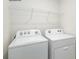 Bright laundry area featuring a white washer and dryer set with wire shelving for optimal storage solutions at 1766 Falls Cove Rd, Newton, NC 28658