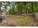 Large backyard with mature trees, a wooden deck, play equipment, and ample space for outdoor activities at 2000 Shannon Bridge Ln, Matthews, NC 28105