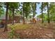 Spacious backyard with a wooden deck, playset, mature trees, and plenty of room to roam at 2000 Shannon Bridge Ln, Matthews, NC 28105