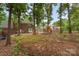 Expansive backyard featuring a play area, mature trees, and a charming brick home at 2000 Shannon Bridge Ln, Matthews, NC 28105