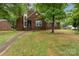 Beautiful brick home with mature trees, well-manicured lawn, and a welcoming pathway to the front door at 2000 Shannon Bridge Ln, Matthews, NC 28105