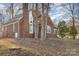 Brick house nestled amongst mature trees, showcasing curb appeal at 2000 Shannon Bridge Ln, Matthews, NC 28105