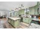 Bright eat-in kitchen with granite counters, modern lighting, stainless appliances and beautiful green cabinets at 2000 Shannon Bridge Ln, Matthews, NC 28105