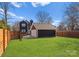 Backyard with grassy lawn, detached garage, and wood fence at 212 Bacon Ave, Charlotte, NC 28208