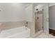 Bathroom featuring a soaking tub and glass-enclosed shower with decorative tile accents at 212 Bacon Ave, Charlotte, NC 28208