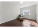 Bedroom features hardwood floors, chair with ottoman, neutral walls, and natural light at 212 Bacon Ave, Charlotte, NC 28208