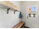 Welcoming entryway features bench, hooks, shelf, and door with natural light at 212 Bacon Ave, Charlotte, NC 28208