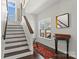 Entryway featuring hardwood floors, staircase with runner, and natural light from windows at 212 Bacon Ave, Charlotte, NC 28208