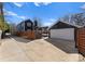 Home exterior showcasing a large driveway and detached garage with a pergola covered deck at 212 Bacon Ave, Charlotte, NC 28208