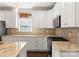 Well-lit kitchen featuring granite countertops, custom cabinets, and stainless steel appliances at 212 Bacon Ave, Charlotte, NC 28208