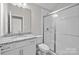 Bright bathroom featuring a granite countertop vanity and a glass-enclosed tiled shower at 240 Portrait Way # 87, Indian Trail, NC 28079